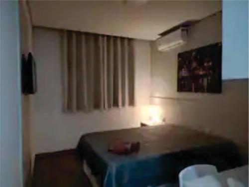 a hotel room with a bed and a window at Flats da Júnia - ótimo beneficio com wifi, ar, tv, frigobar in Lagoa Santa