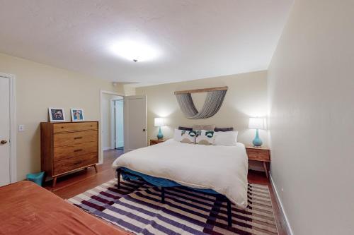 Un dormitorio con una gran cama blanca y una cómoda. en Rooster Cottage, en Healdsburg