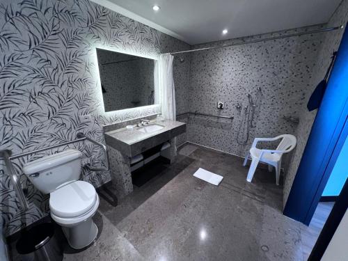 a bathroom with a toilet and a sink and a mirror at Holiday Inn Bogota Airport by IHG in Bogotá