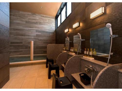 a bathroom with a counter with chairs and a mirror at QUEEN'S HOTEL CHITOSE - Vacation STAY 67732v in Chitose