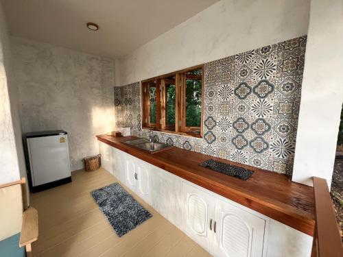 a kitchen with a counter with a sink and a refrigerator at Siam Cookies Cottage in Haad Pleayleam