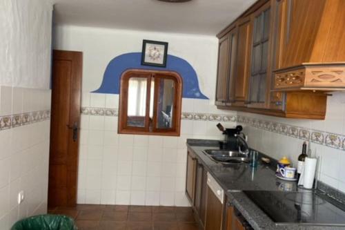 eine Küche mit einem Waschbecken und einer Uhr an der Wand in der Unterkunft casa vacacional in Almonte