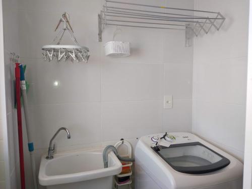 a small bathroom with a tub and a sink at Aconchegante Apto Praia do Centro in Itanhaém