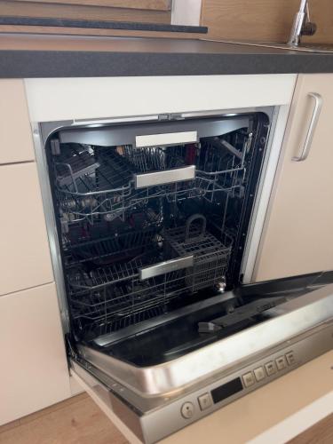 a dishwasher with its door open in a kitchen at Ferienwohnung am Bauernhof, Korbingerhof in Rinn
