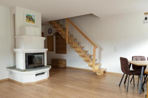 a living room with a fireplace and a staircase at Ferienwohnung am Bauernhof, Korbingerhof in Rinn