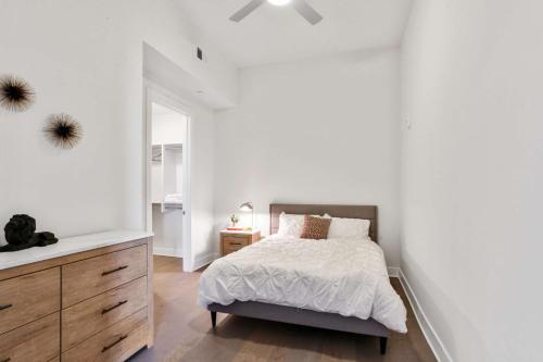 a white bedroom with a bed and a dresser at Midtown Luxury Apartment in Atlanta