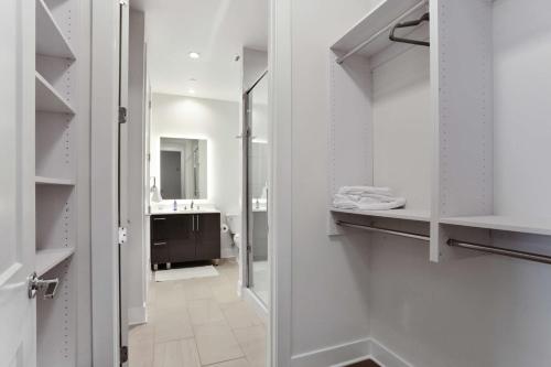a bathroom with white cabinets and a walk in closet at Midtown Luxury Apartment in Atlanta