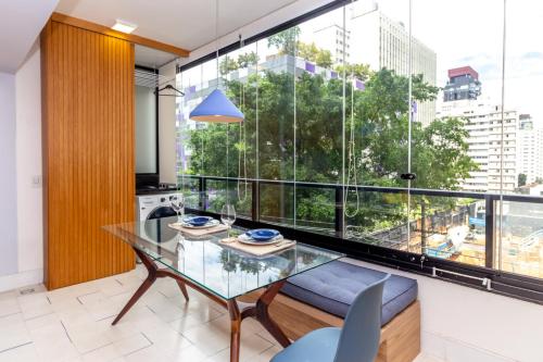 een eetkamer met een glazen tafel en een groot raam bij 360 VN Capote Valente by Housi in Sao Paulo