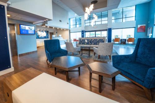 a waiting room with blue chairs and a table at Holiday Inn Express Hotel & Suites Tampa-Oldsmar by IHG in Oldsmar