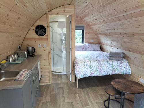 sypialnia w małym domku z łóżkiem i umywalką w obiekcie Gateway Glamping w Farranfore