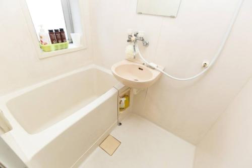 a white bathroom with a sink and a tub and a toilet at Grace Heiwajima - Vacation STAY 15088 in Tokyo