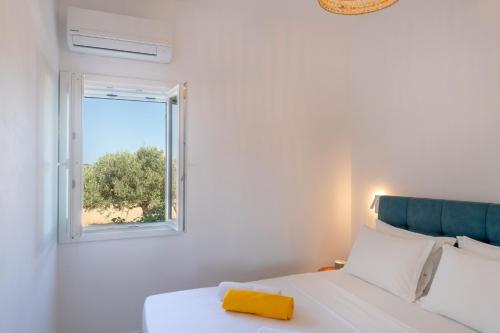 - une chambre avec un lit blanc et une fenêtre dans l'établissement Olivine Paros Villas, à Parikia