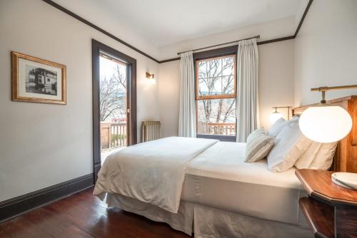 a bedroom with a large white bed and two windows at Naramata Inn in Naramata