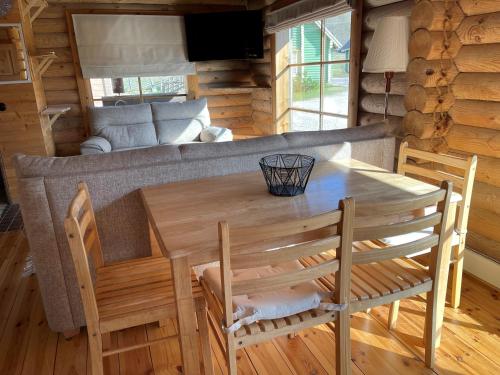 una mesa de comedor y sillas en una cabaña de madera en Nuustakumajad, en Otepää