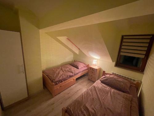 a attic bedroom with two beds and a mirror at Domek w Koszarawie Bystrej in Koszarawa