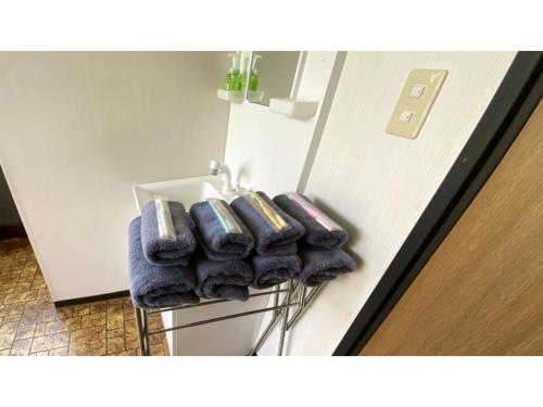 Ein Haufen Handtücher auf einem Regal neben einem Kühlschrank in der Unterkunft Forte "Hachijojima" - Vacation STAY 62473v in Hachijō