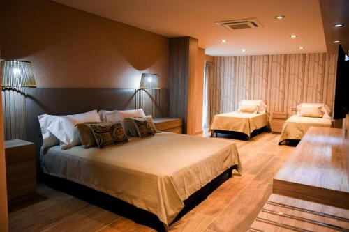 a hotel room with two beds and two lamps at Hotel Cálido Termal in Termas de Río Hondo