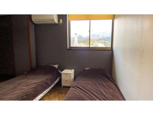 two beds in a small room with a window at Forte "Hachijojima" - Vacation STAY 62466v in Hachijo