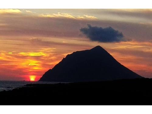 a silhouette of a mountain in front of a sunset at Forte "Hachijojima" - Vacation STAY 62466v in Hachijo