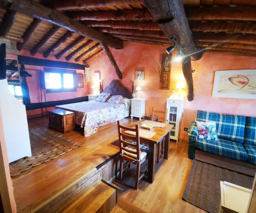 a bedroom with a bed and a table and a couch at Ático Pirón in Adrada de Pirón
