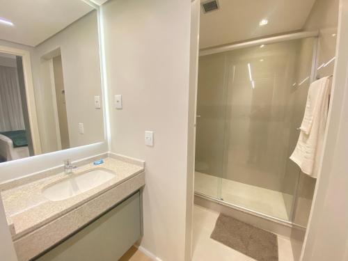 a bathroom with a sink and a shower at Excelente Apto 1Q St Marista - 453 in Goiânia