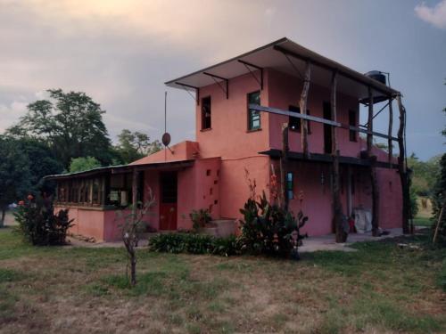 a pink house in a field next to a field at La casa de Sibila in Bragado
