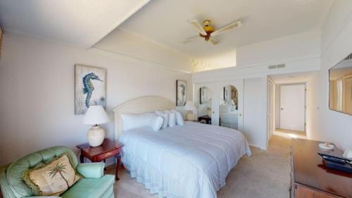 a bedroom with a large white bed and a couch at Osprey Watch 4D in Pawleys Island