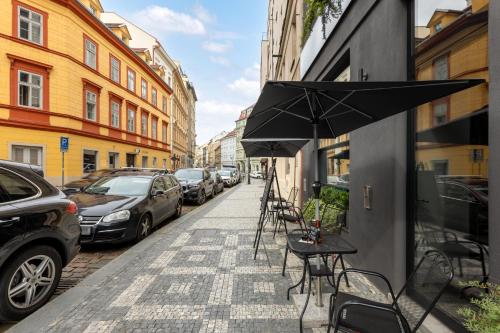 a sidewalk with tables and chairs and an umbrella at Numa Prague Republika in Prague