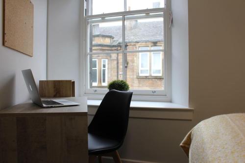 una scrivania con un computer portatile accanto a una finestra di The Arches The Wee Yin a Stirling