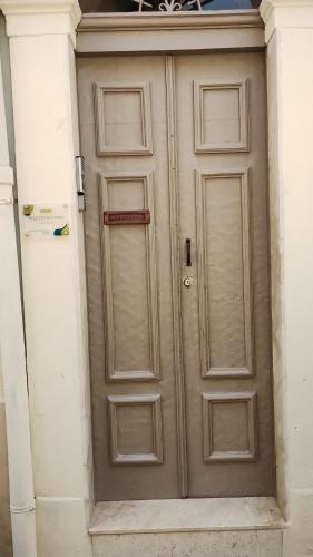 una porta marrone su un edificio bianco con di PONTEVECCHIO Accomodation a Ragusa