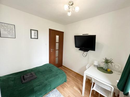 a bedroom with a bed and a tv on the wall at Anielewicza 26 Rooms in Warsaw