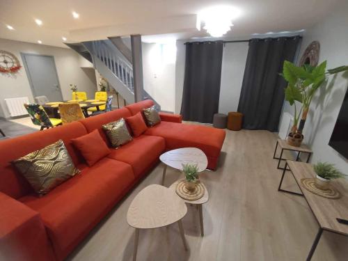 a living room with a red couch and tables at Le palais duplex in Autun
