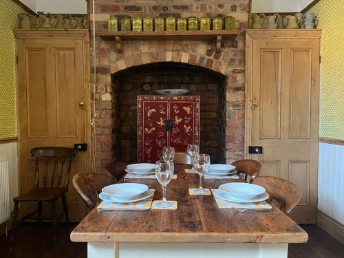 a table with plates and wine glasses and a fireplace at Stunning Whitley Bay apartment in Whitley Bay