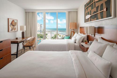 um quarto de hotel com duas camas e uma secretária e uma janela em The Westin Fort Lauderdale Beach Resort em Fort Lauderdale