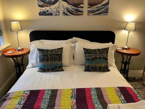 - un lit avec des oreillers et 2 tables de chevet dans l'établissement Stunning Whitley Bay apartment, à Whitley Bay