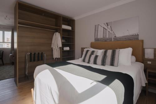 a bedroom with a large bed and a closet at Açores Premium- Aeroporto 15 minutos in Porto Alegre