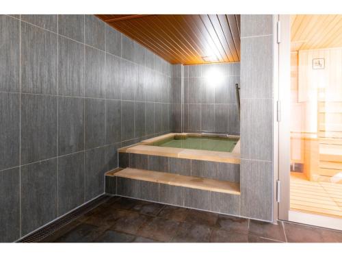金沢市にあるTorifito Hotel & Pod Kanazawa - Vacation STAY 88230vのグレーのタイル張りのバスルーム(ジャクジータブ付)