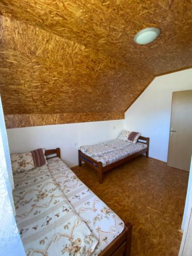a room with two beds in a room with a ceiling at Apartmani Bozovic in Žabljak