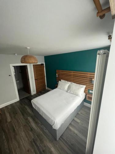 a bedroom with a white bed and a blue wall at No.5 in Derry Londonderry