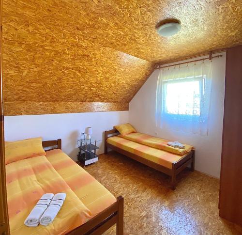 a bedroom with two beds in a room with a yellow ceiling at Apartmani Bozovic in Žabljak