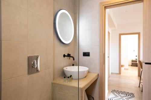 ein Badezimmer mit Waschbecken und Spiegel in der Unterkunft Portogal Apartments in Argostoli