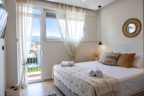 ein Schlafzimmer mit einem großen Bett und einem großen Fenster in der Unterkunft Portogal Apartments in Argostoli