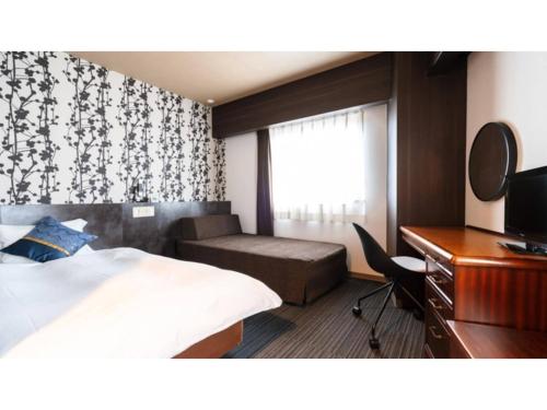 a hotel room with a bed and a desk and a mirror at Hotel AreaOne Minamisoma - Vacation STAY 56242v in Minamisouma
