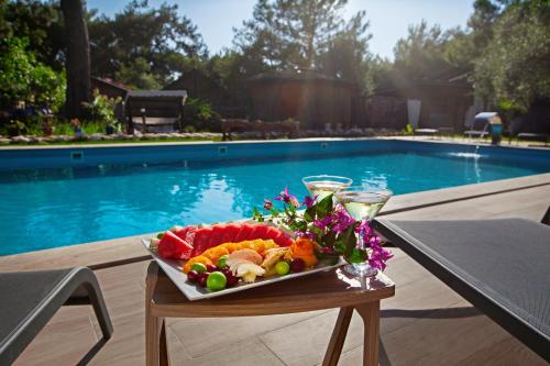 a tray of food on a table next to a pool at Chakra Beach Kabak in Faralya