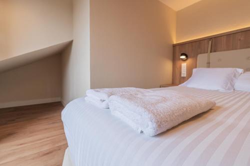 a bedroom with a large bed with white sheets at Hotel BESTPRICE Santillana in Santillana del Mar