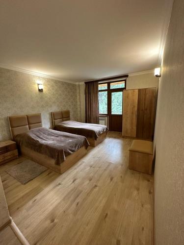 two beds in a room with wooden floors at Sochiner Hotel in Vanadzor