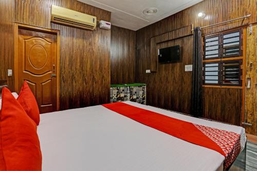 um quarto com uma cama com painéis de madeira e uma televisão em Hotel Parvesh em Farrukhnagar