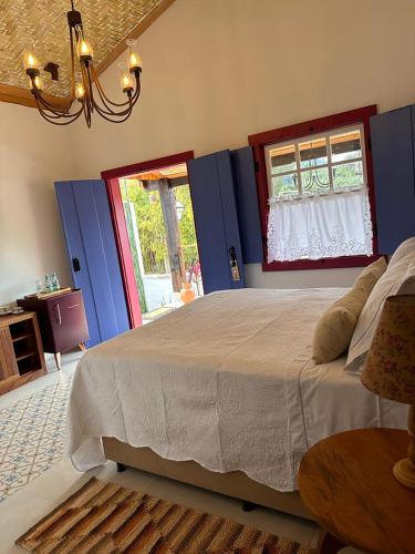 a bedroom with a large bed and a window at Chafariz Por Um Triz Pousada de Charme in Tiradentes
