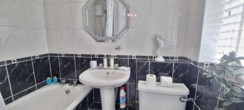 a bathroom with a sink and a toilet and a mirror at Toffees Townhouse 2 Bed House in Liverpool 2 Mins walk Goodison Park in Liverpool