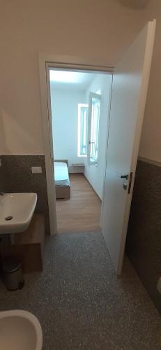 a bathroom with a toilet and a sink and a door at La casa gialla del Ristoro Agricolo Vecchiano in Vecchiano